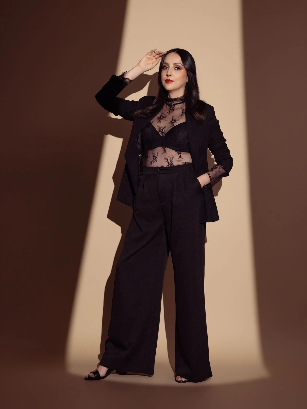 Retrato editorial de mujer con traje negro realizado en estudio.