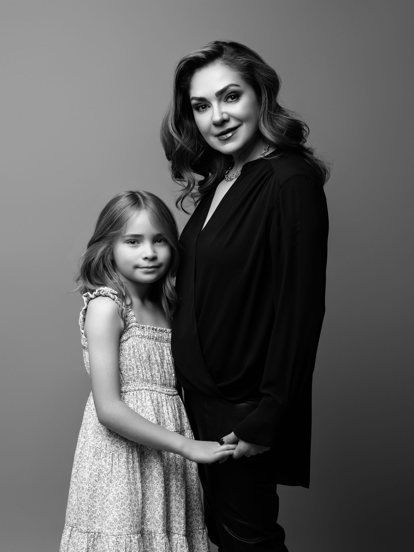Retrato familiar de madre e hija en blanco y negro realizado en estudio.