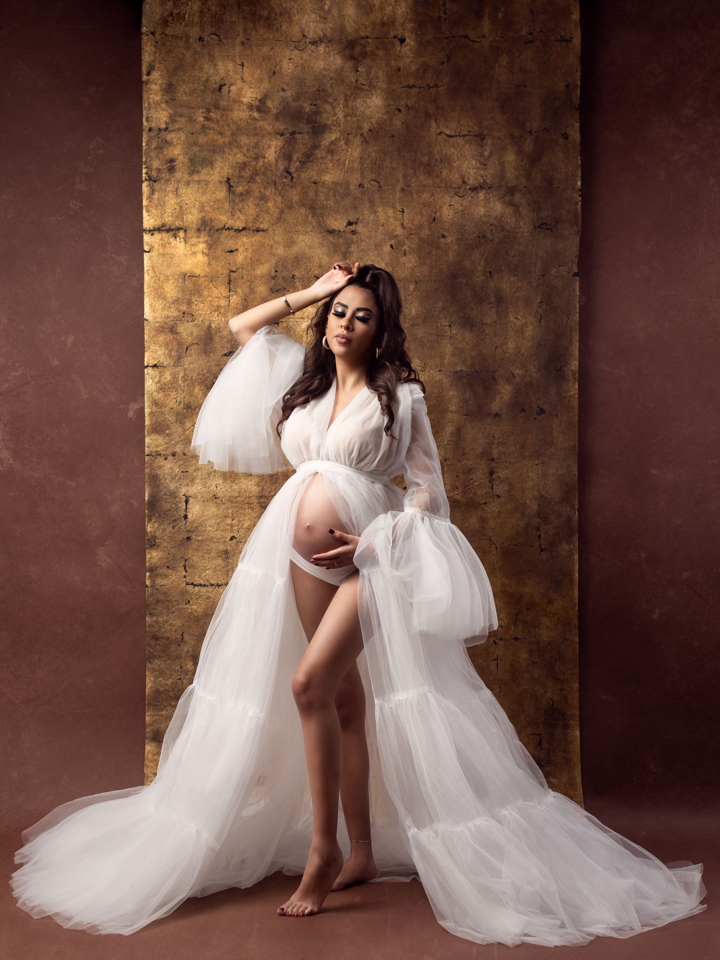Fotografía de embarazo con vestido de tul en estudio fotográfico.
