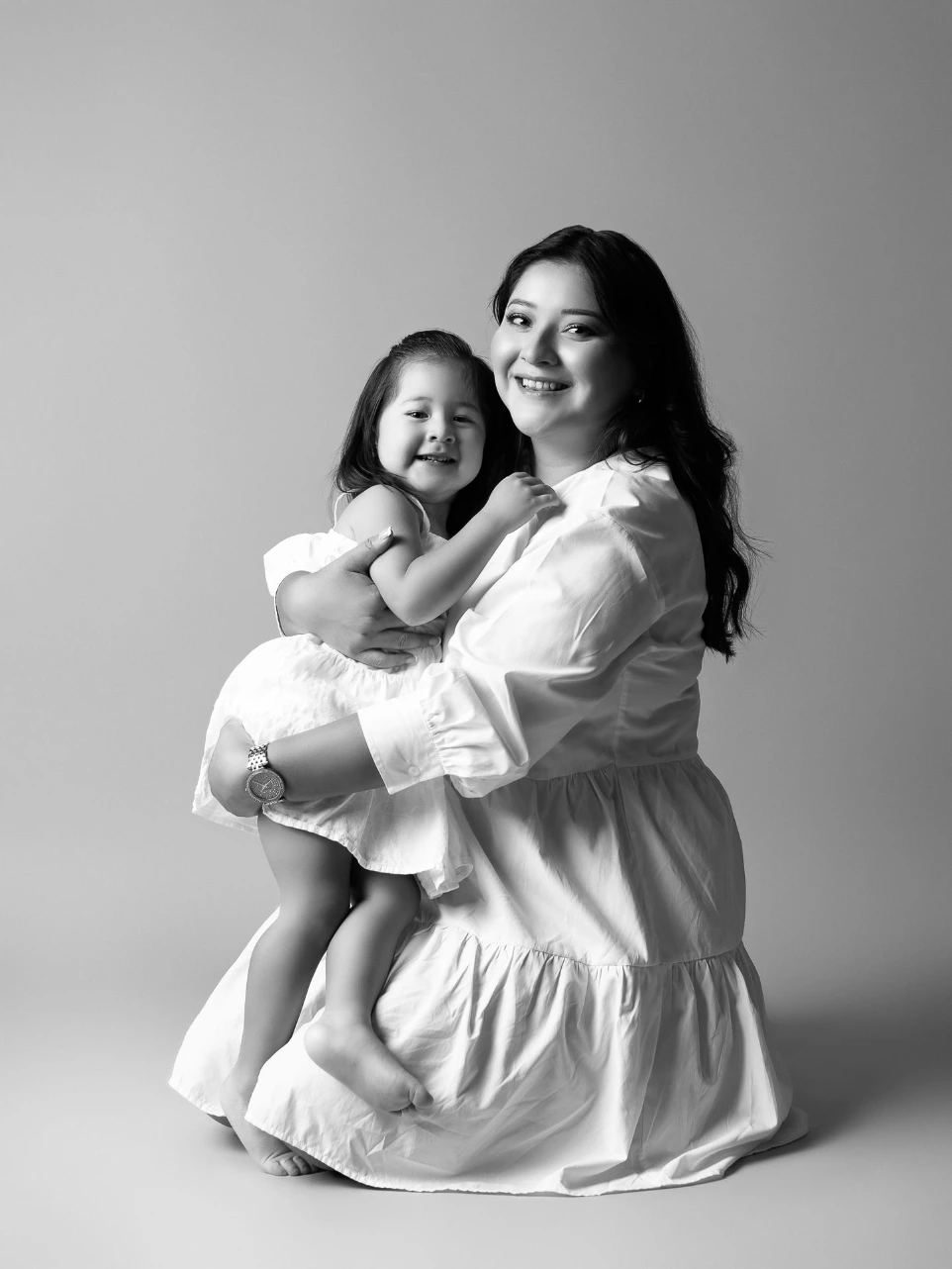 Sesión familiar de madre e hija realizada con fondo neutro en estudio en Atizapán de Zaragoza, Estado de México..