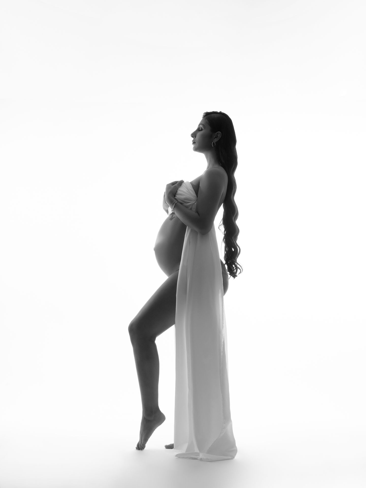 Fotografía de maternidad artística en blanco y negro con iluminación suave y estilo editorial realizado en estudio en Atizapán de Zaragoza, Estado de México.