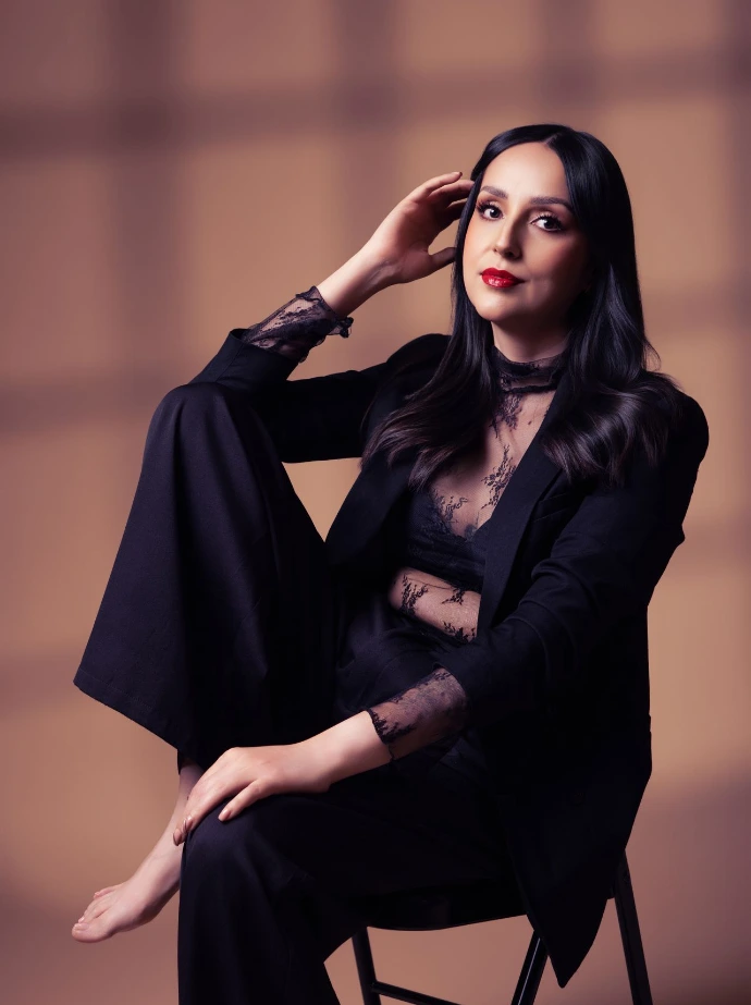 Retrato femenino editorial con iluminación dramática y fondo oscuro.