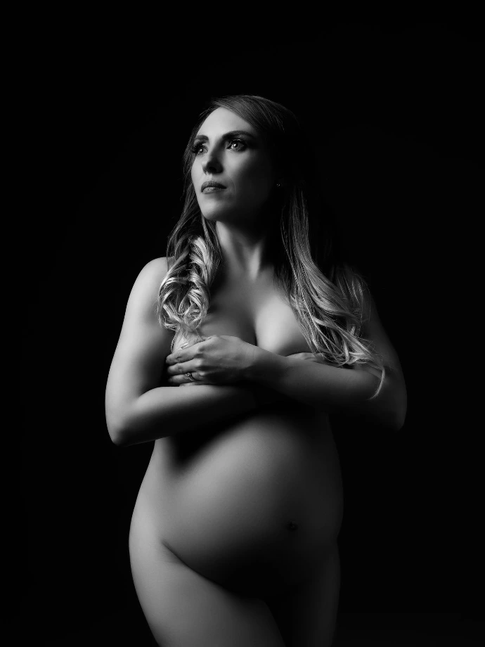 Fotografía de maternidad en blanco y negro con iluminación clásica.