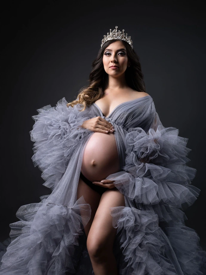 Retrato de embarazo con vestido de tul y corona de flores.