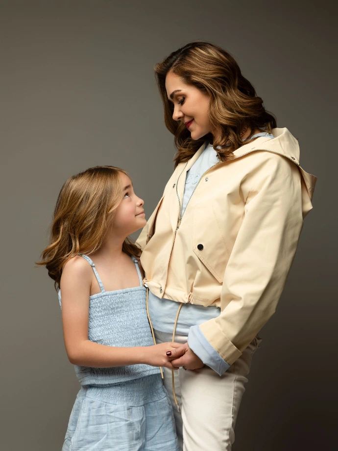 Retrato familiar de madre e hija con iluminación natural en estudio.