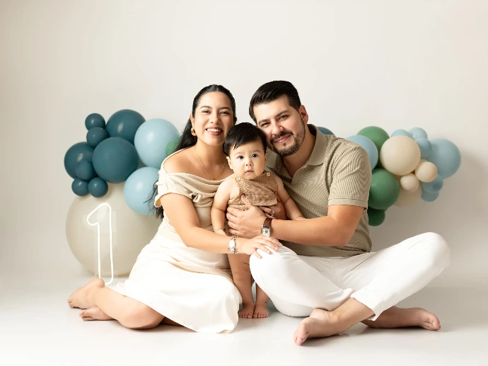 Sesión familiar de padres e hijo celebrando el primer cumpleaños.