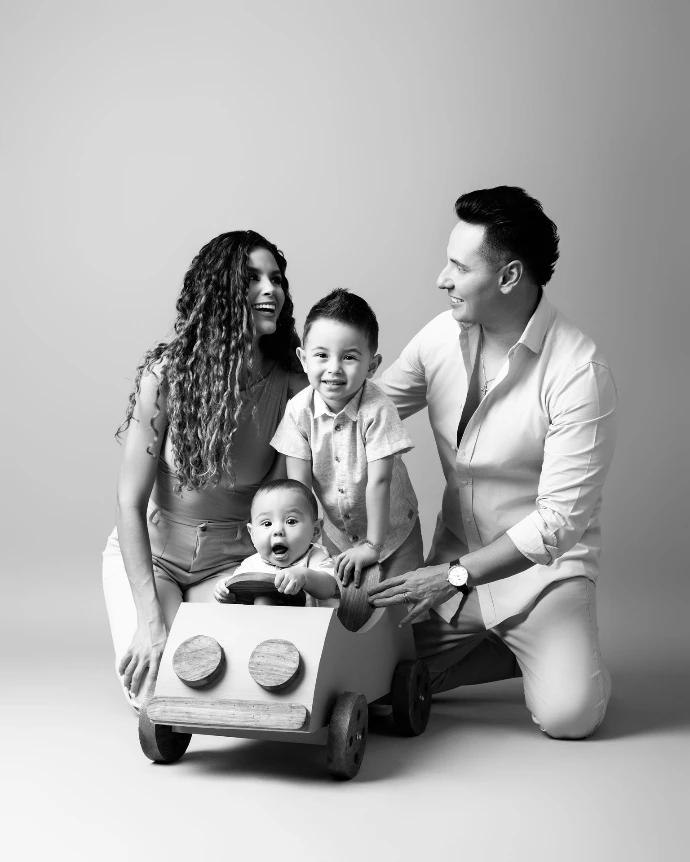 Retrato familiar en blanco y negro de padres e hijo realizado en estudio.