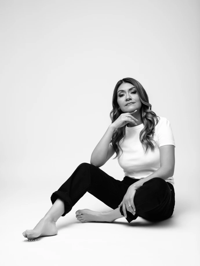 Retrato femenino en blanco y negro con fondo claro y estilo minimalista.